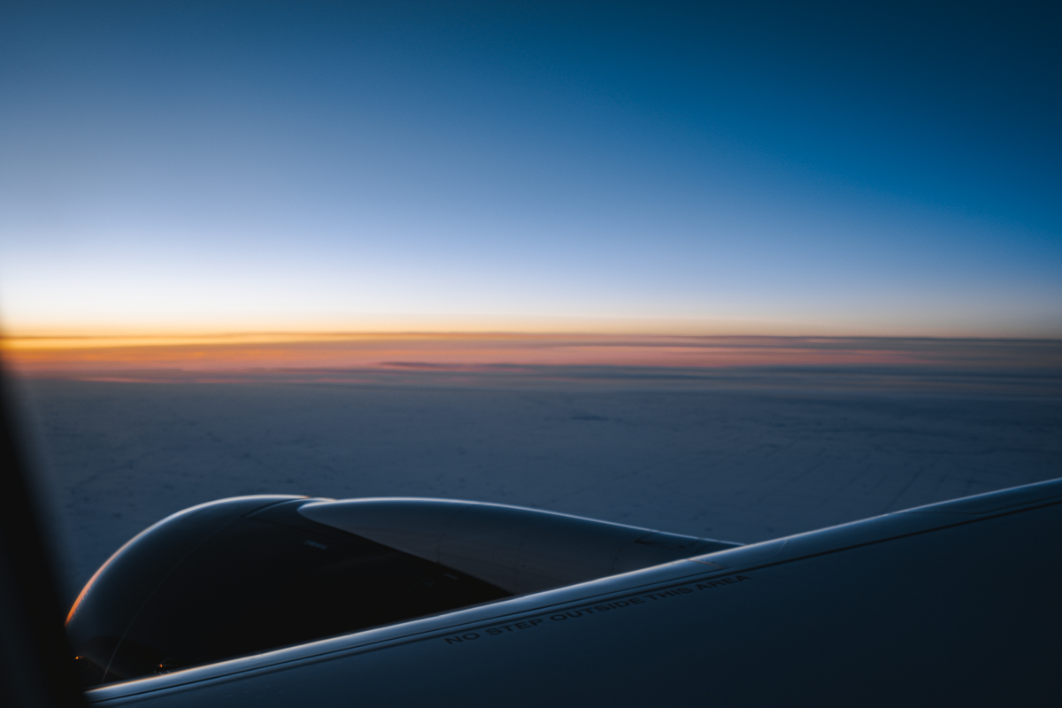Air Canada A220 engine and wing view with sunrise