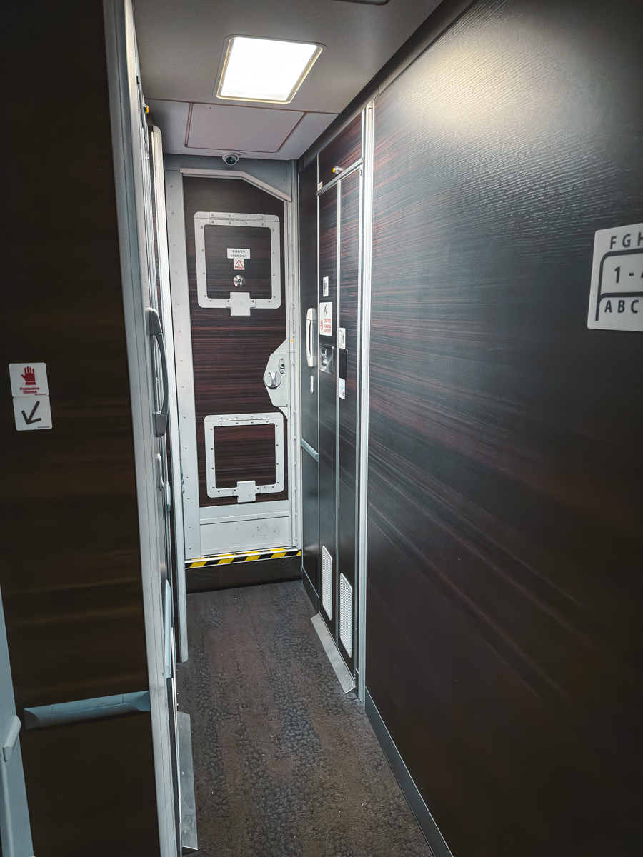 Hallway leading to cockpit door with lavatories on both sides.