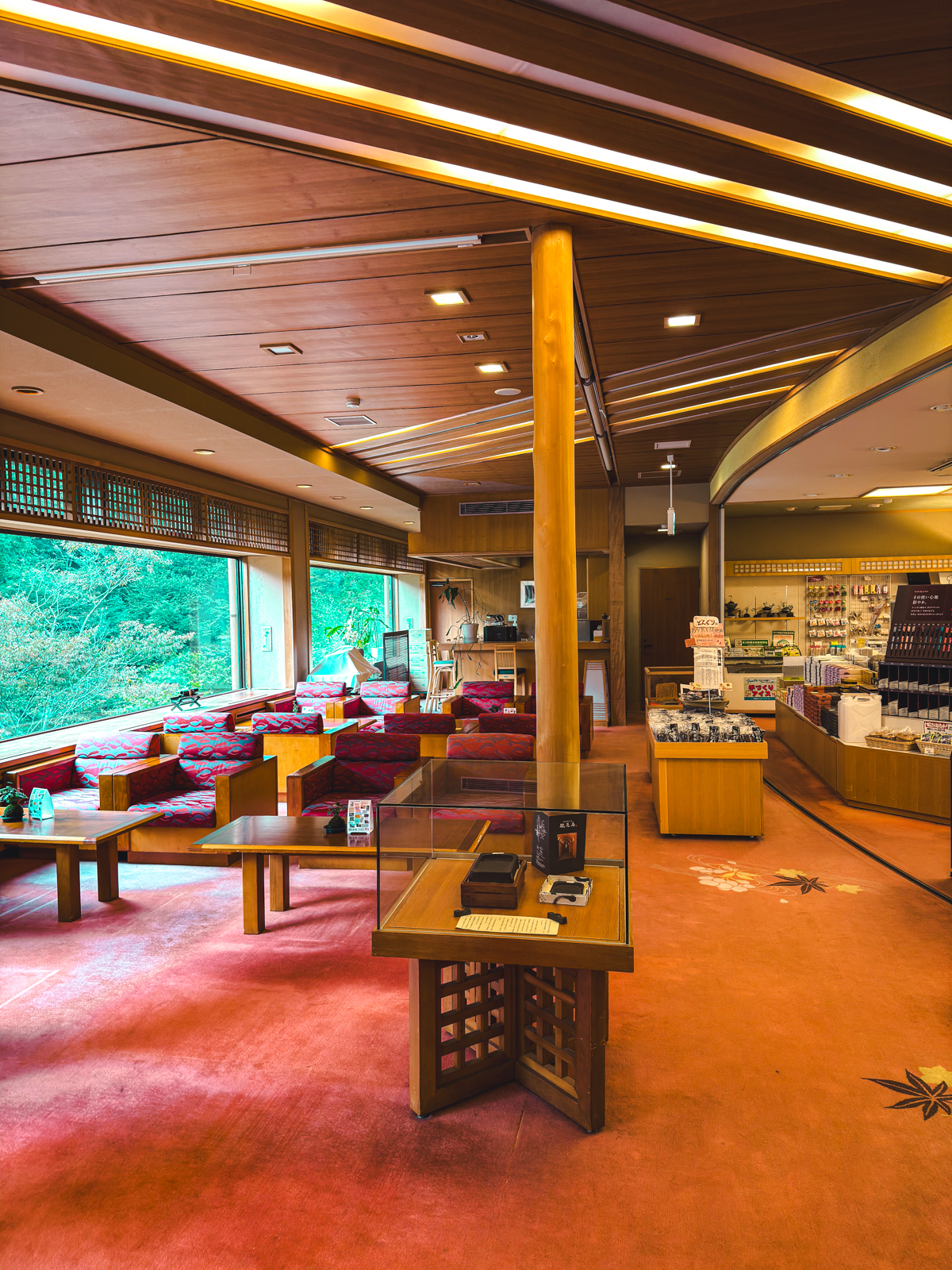 Nishiyama Onsen lobby area with red carpets, gift shop on the right and windows on the left.