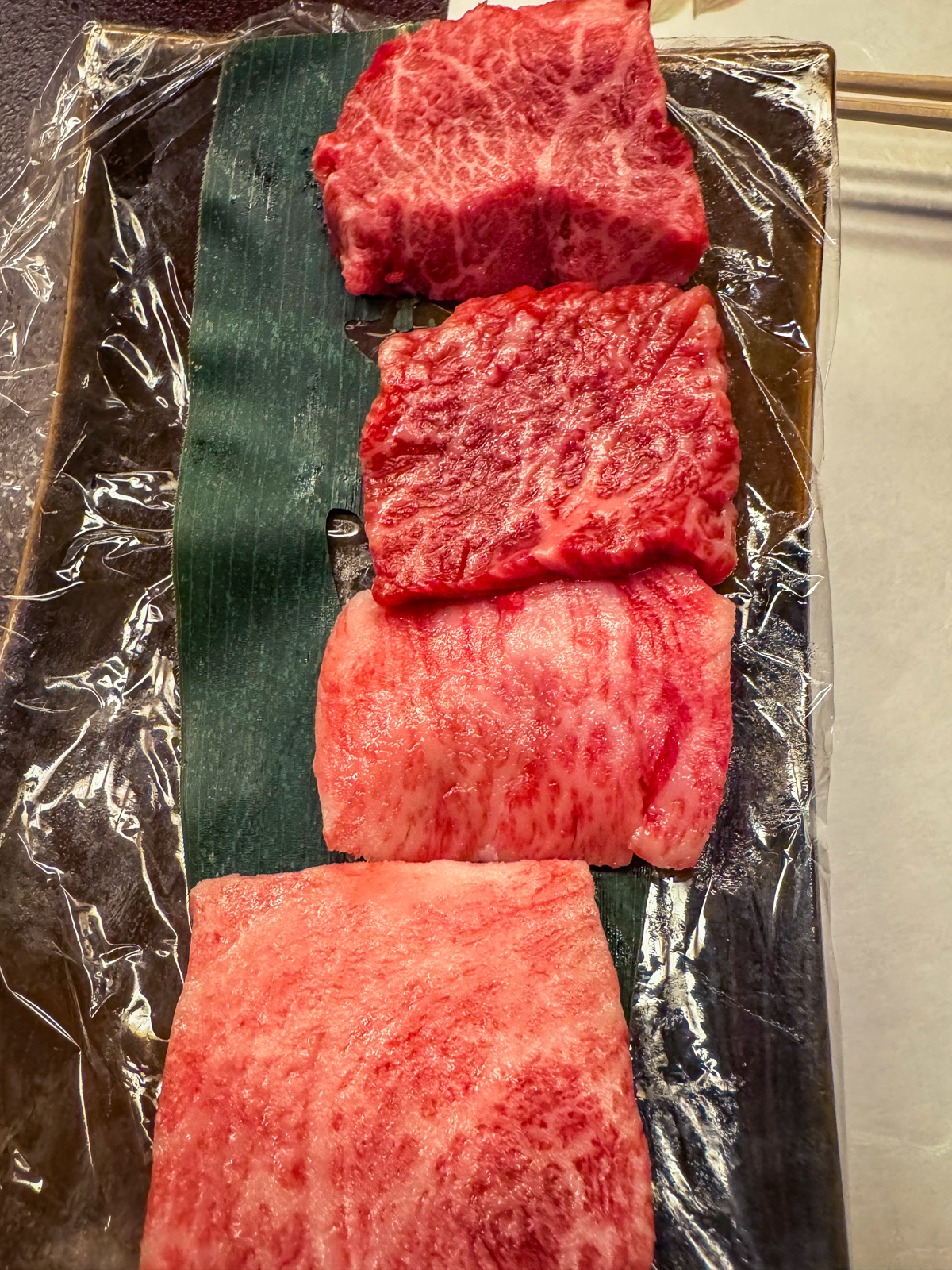 Close-up shots of the 4 pieces of wagyu glistening with marbling.