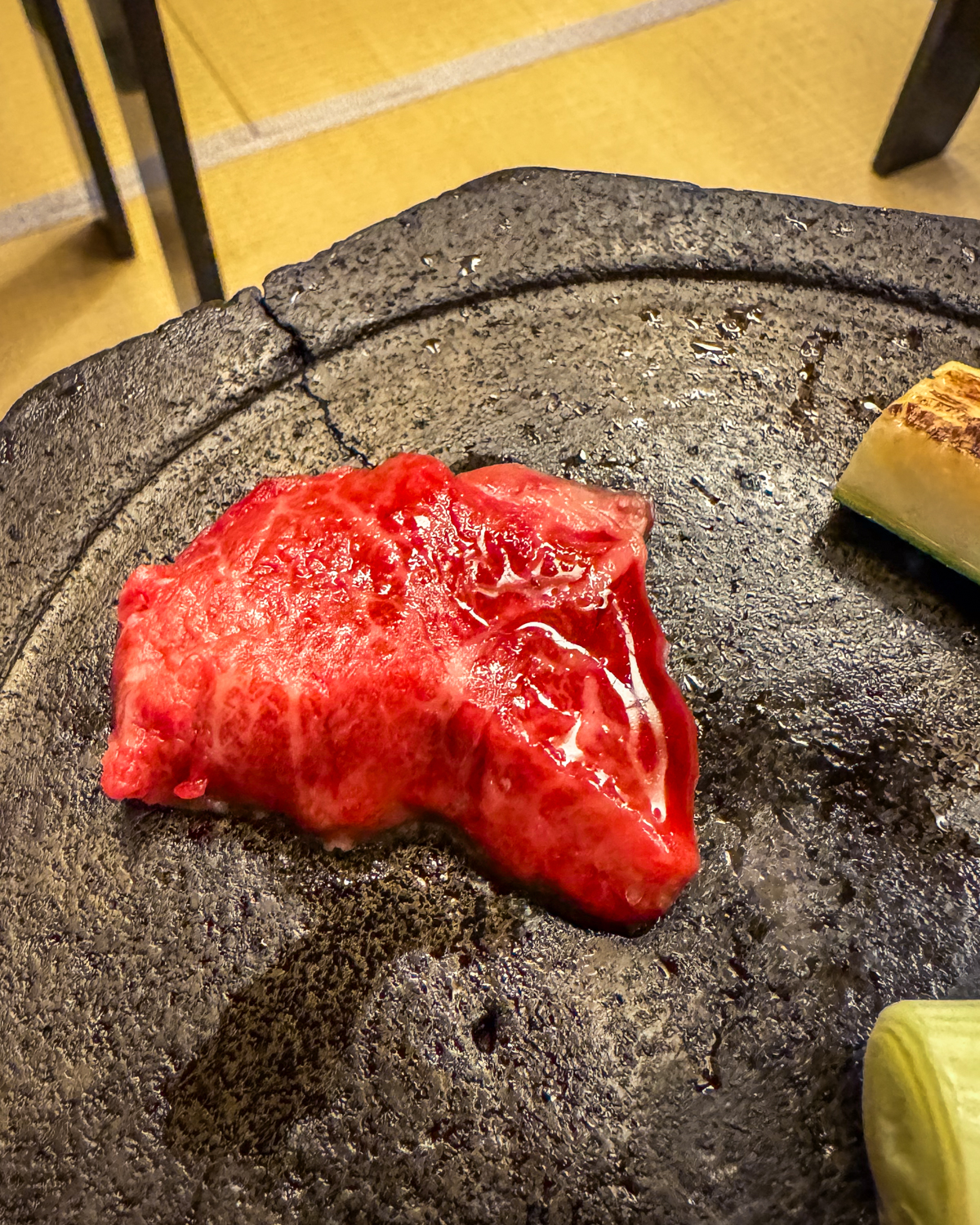 Piece of wagyu being grilled on the stone plate.